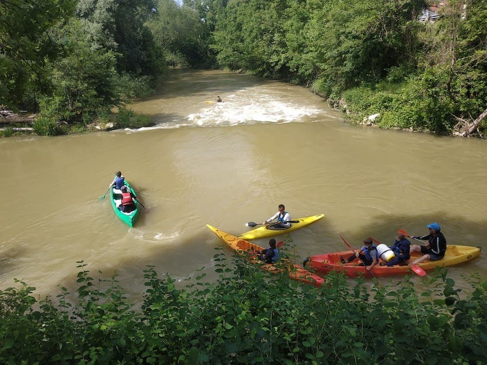 Des kayaks devant une vague.
